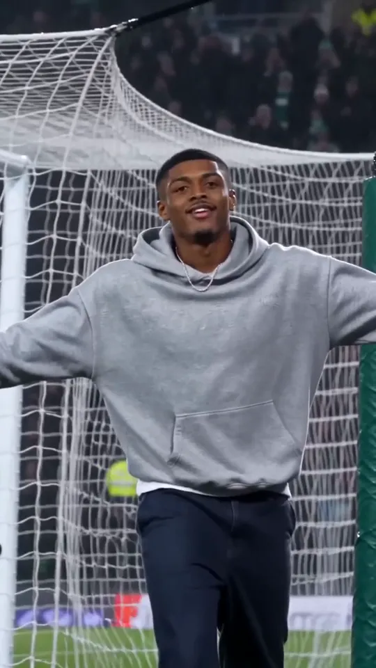 Ozil goal AI video frame: he smiles at the camera with his arms wide in front of the net